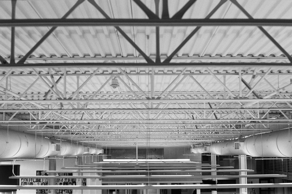 Monochrome view of an industrial ceiling with metal beams and ductwork in Vancouver.